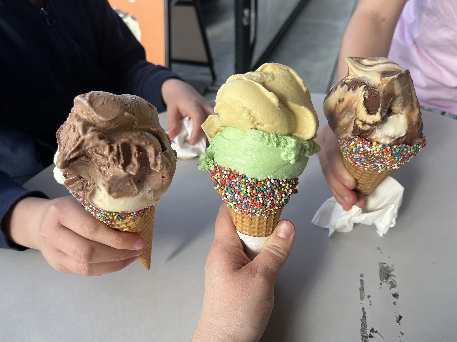 Three ice cream cones with sprinkles. The photo was not taken at a Horizon West shop.